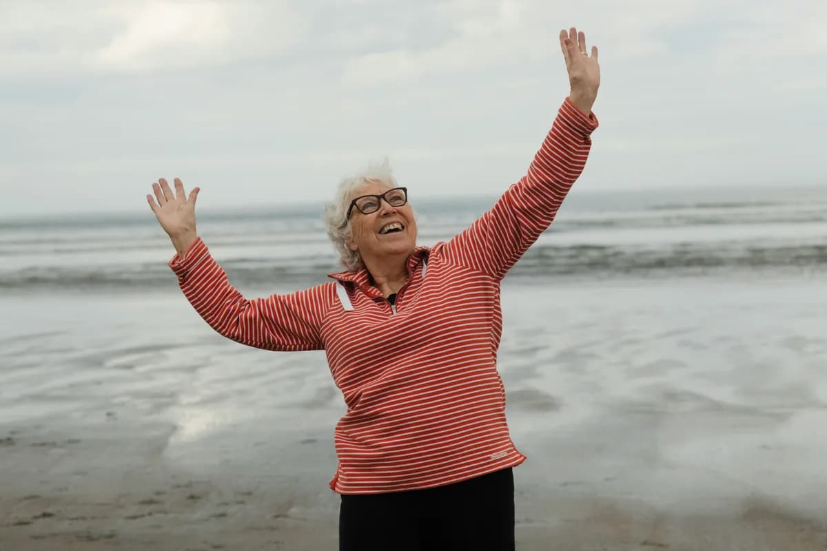 An elderly lady having a good time at the beach, smiling