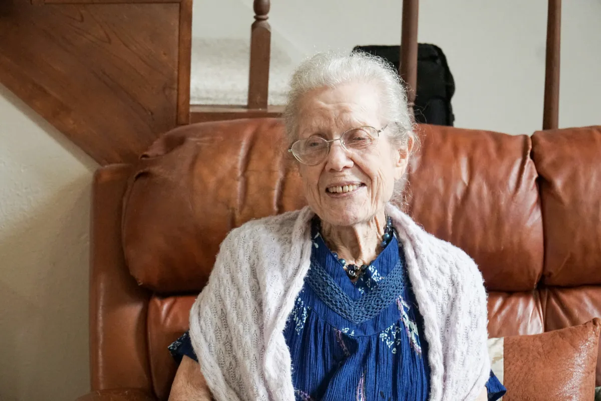 an elderly woman smiling in a care home