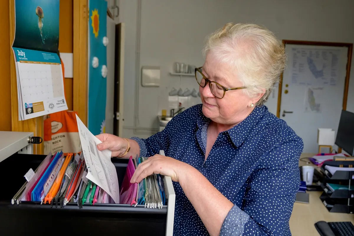 an elderly lady searching for a document in a care home